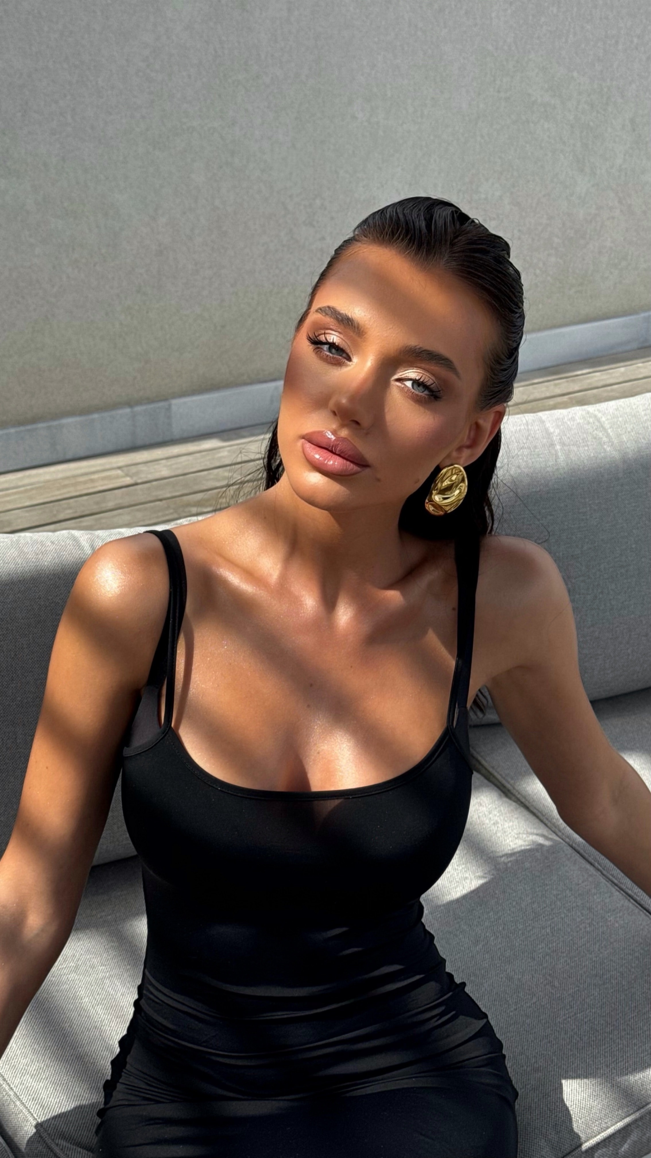 Sleek pulled-back hair, bronzed skin